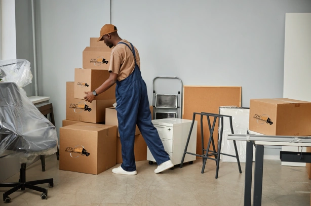Déménageur empilant des cartons dans un bureau